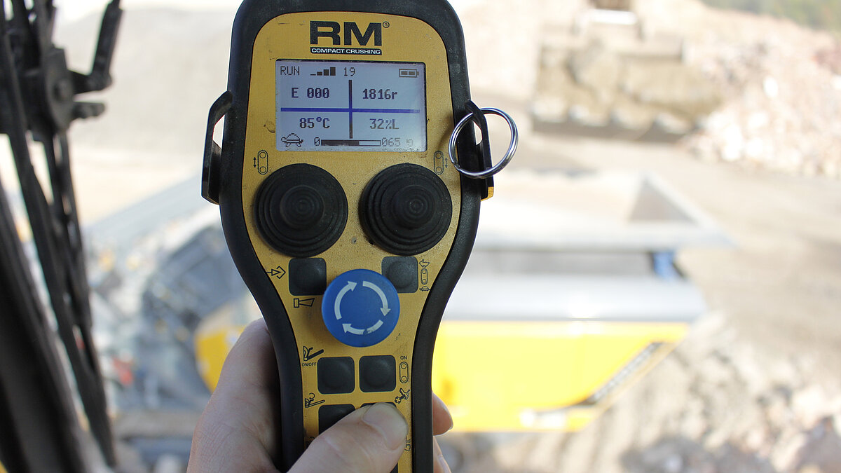 Crusher operator in excavator cab with radio remote control